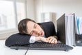 Tired overworked man is sleeping on keyboard in office at work Royalty Free Stock Photo