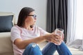 Tired overworked sad mature woman with glass of water sitting at home on the floor Royalty Free Stock Photo