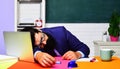 Tired overworked teacher sleep at desk. Knowledge, education and learning concept. Sleeping male student in classroom Royalty Free Stock Photo