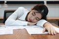 Tired overworked young Asian business woman lying down on the desk in office Royalty Free Stock Photo