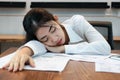 Tired overworked young Asian business woman lying down on the desk in office Royalty Free Stock Photo