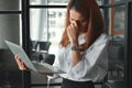 Tired overworked young Asian business woman suffering from severe depression in workplace of office. Royalty Free Stock Photo