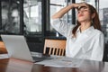 Tired overworked young Asian business woman suffering from severe depression in workplace. Royalty Free Stock Photo