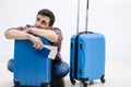 Delayed aeroplane concept. Tired passenger is napping on luggage in airport terminal and waiting for airplane arrival. Royalty Free Stock Photo