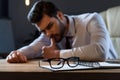 tired pensive businessman leaning on table with glasses