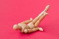 Tired powerless wooden man fallen  on the red background Royalty Free Stock Photo