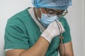 Tired praying doctor at the hospital. A doctor, a nurse who is thinking about treating a disease and a pandemic. Surgeon after Royalty Free Stock Photo