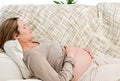 Tired pregnant woman relaxing on her sofa Royalty Free Stock Photo