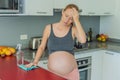 A tired pregnant woman sits in the kitchen after cleaning. Health and vitality of a pregnant woman Royalty Free Stock Photo