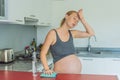 A tired pregnant woman sits in the kitchen after cleaning. Health and vitality of a pregnant woman Royalty Free Stock Photo