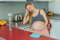 A tired pregnant woman sits in the kitchen after cleaning. Health and vitality of a pregnant woman Royalty Free Stock Photo