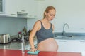 A tired pregnant woman sits in the kitchen after cleaning. Health and vitality of a pregnant woman Royalty Free Stock Photo