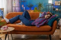 Tired young woman lying down on comfortable couch taking a rest, daytime nap relaxing falling asleep Royalty Free Stock Photo