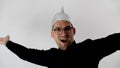 Man takes off his foil hat, bows, smiles, puts a tinfoil helmet to the brains on his head. Emotional handsome guy with glasses. Royalty Free Stock Photo