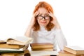 Tired red-haired girl in glasses with books