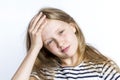 Tired red-haired girl touches her forehead with her hand. Health and stress. Close-up. White background