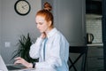 Tired redhead young business woman having neck pain during working at laptop compute Royalty Free Stock Photo