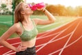 Tired runner drinks water from a bottle.