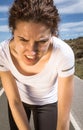 Tired runner girl sweating after running with sun