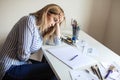 Tired sad calligraphy artist sitting at desk