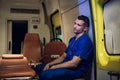 Tired and sad corpsman sits inside the ambulance car