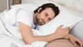 Tired sad depressed millennial caucasian man with stubble cant fall asleep in white bed, suffer from health problems Royalty Free Stock Photo