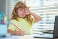 Tired sad school boy while doing homework. Child hold a pencil and draw at home. Schoolboy teen drawing sitting at the Royalty Free Stock Photo