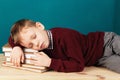 Tired school boy asleep on books. little student sleeping on tex Royalty Free Stock Photo