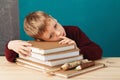 Tired school boy asleep on books. little student sleeping on tex Royalty Free Stock Photo