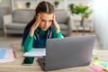 Tired school girl doing homework grabbing her head using laptop Royalty Free Stock Photo