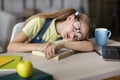 Tired school girl in glasses sleeping at table with book Royalty Free Stock Photo