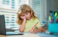 Tired schoolboy while doing homework. Child writing homework in school class. Funny child girl doing homework writing Royalty Free Stock Photo