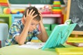 Portrait of tired schoolboy doing homework in classroom Royalty Free Stock Photo