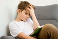 Tired schoolboy hardly working on his homework at home - boy is tired, frustrated and immersed. Studying online at home Royalty Free Stock Photo