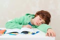 Tired schoolboy sleep at the table during homework. Studying difficulties, education, homework concept. ld Royalty Free Stock Photo