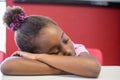Tired schoolgirl sleeping in classroom