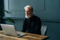 Tired senior aged gray-haired male looking at laptop screen feels confused has difficulties with device, not understand Royalty Free Stock Photo