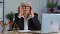 Tired senior business woman office freelancer teacher using laptop suffering from migaine headache Royalty Free Stock Photo