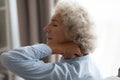 Tired senior grandma rubbing stiff neck suffering from fibromyalgia pain Royalty Free Stock Photo