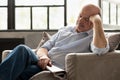 Tired senior hispanic man sleeping on couch, taking afternoon nap