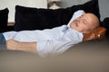 Tired senior hispanic man sleeping on couch, taking afternoon nap