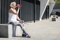 Tired senior lady having rest after exercise beside metal fence Royalty Free Stock Photo