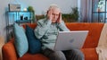 Tired senior man freelancer use laptop suffering from headache problem tension and migraine, stress Royalty Free Stock Photo