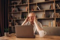 Tired senior man having a headache in library after using the computer Royalty Free Stock Photo