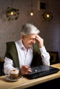 Tired senior man with laptop in the bar Royalty Free Stock Photo