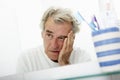 Tired Senior Man Looking At Reflection In Bathroom Mirror