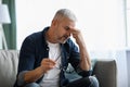 Tired senior man removing glasses, rubbing nose bridge