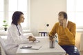 Doctor listening to senior male patient complaining about headache, stress and fatigue Royalty Free Stock Photo