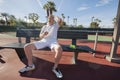 Tired senior tennis player relaxing on bench at court Royalty Free Stock Photo