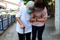 Tired senior woman wearing hygienic mask walk outdoor on street sidewalk in city,feel sick,vertigo,nauseous,allergy to dust, Royalty Free Stock Photo